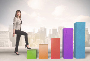 Business person climbing up on colourful chart pillars concept o
